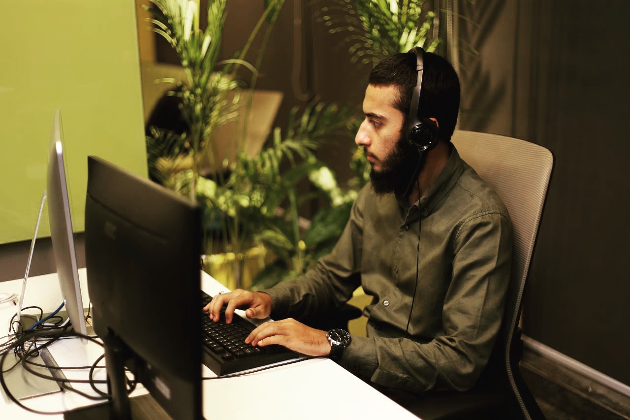 Hunain focused with headphones at the office